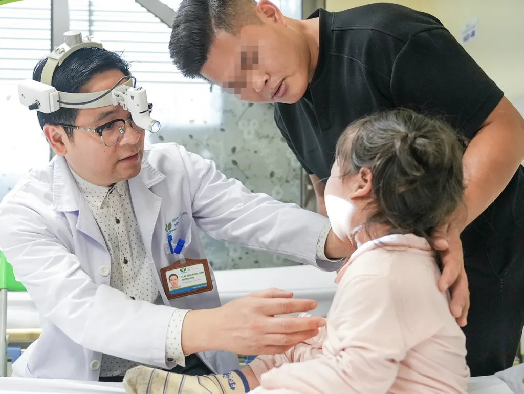 TS.BS. Đặng Hoàng Thơm – Trưởng khoa Sọ mặt và Tạo hình thăm khám cho bệnh nhi sau phẫu thuật